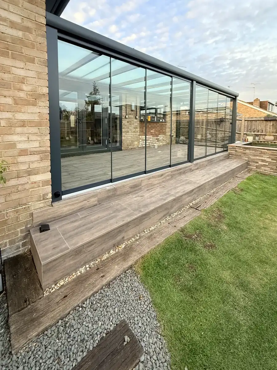Side of the glass room along the edge of the raised terrace