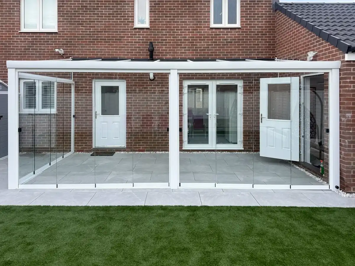 Front view of the white glass room, with French doors behind the sliding glass walls