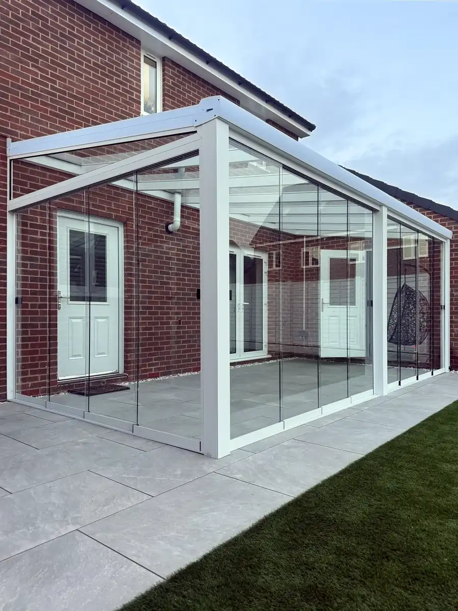 Corner of the white glass room with sliding glass walls on two sides