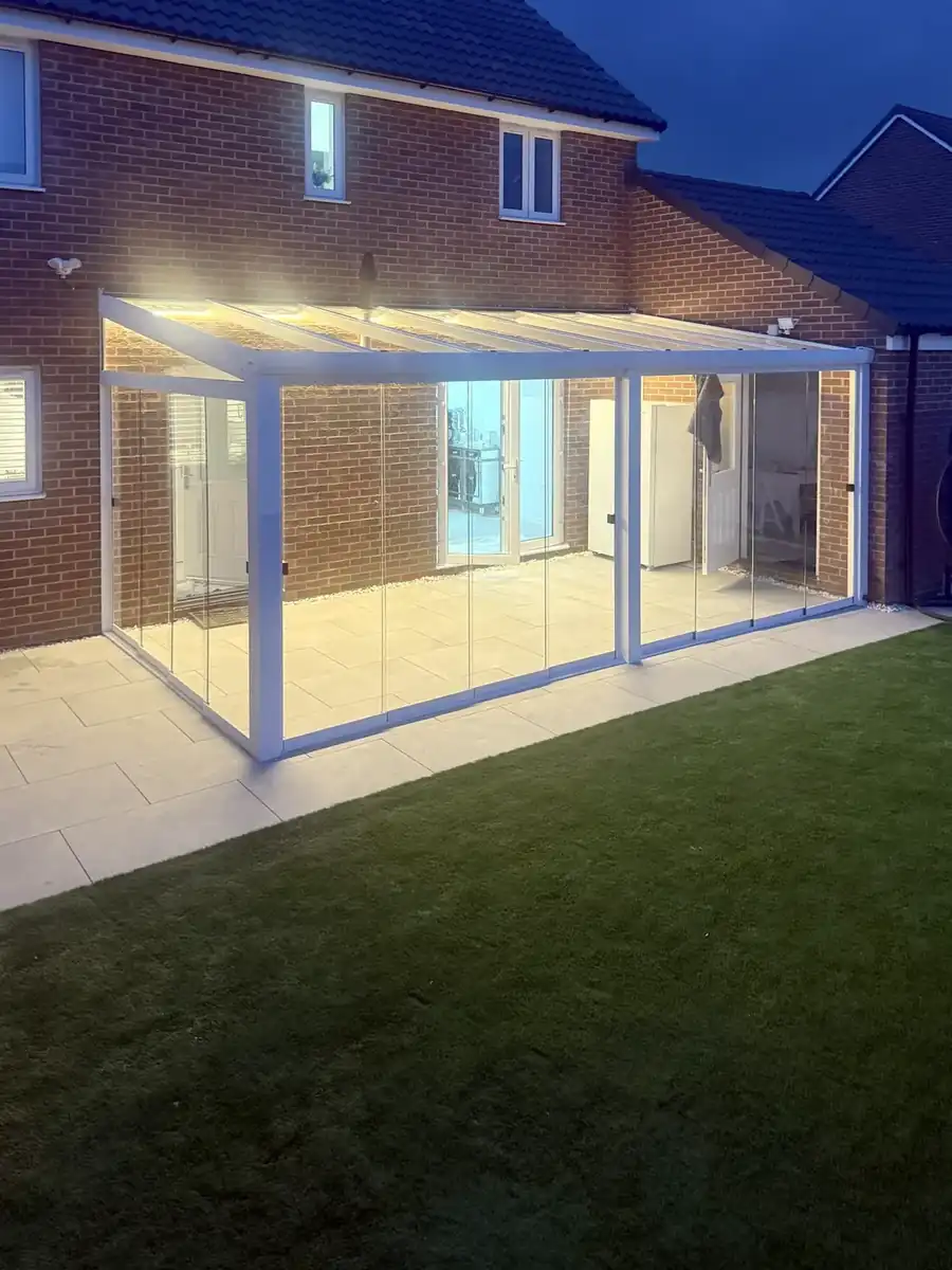 White glass room lit by LED strips in the evening