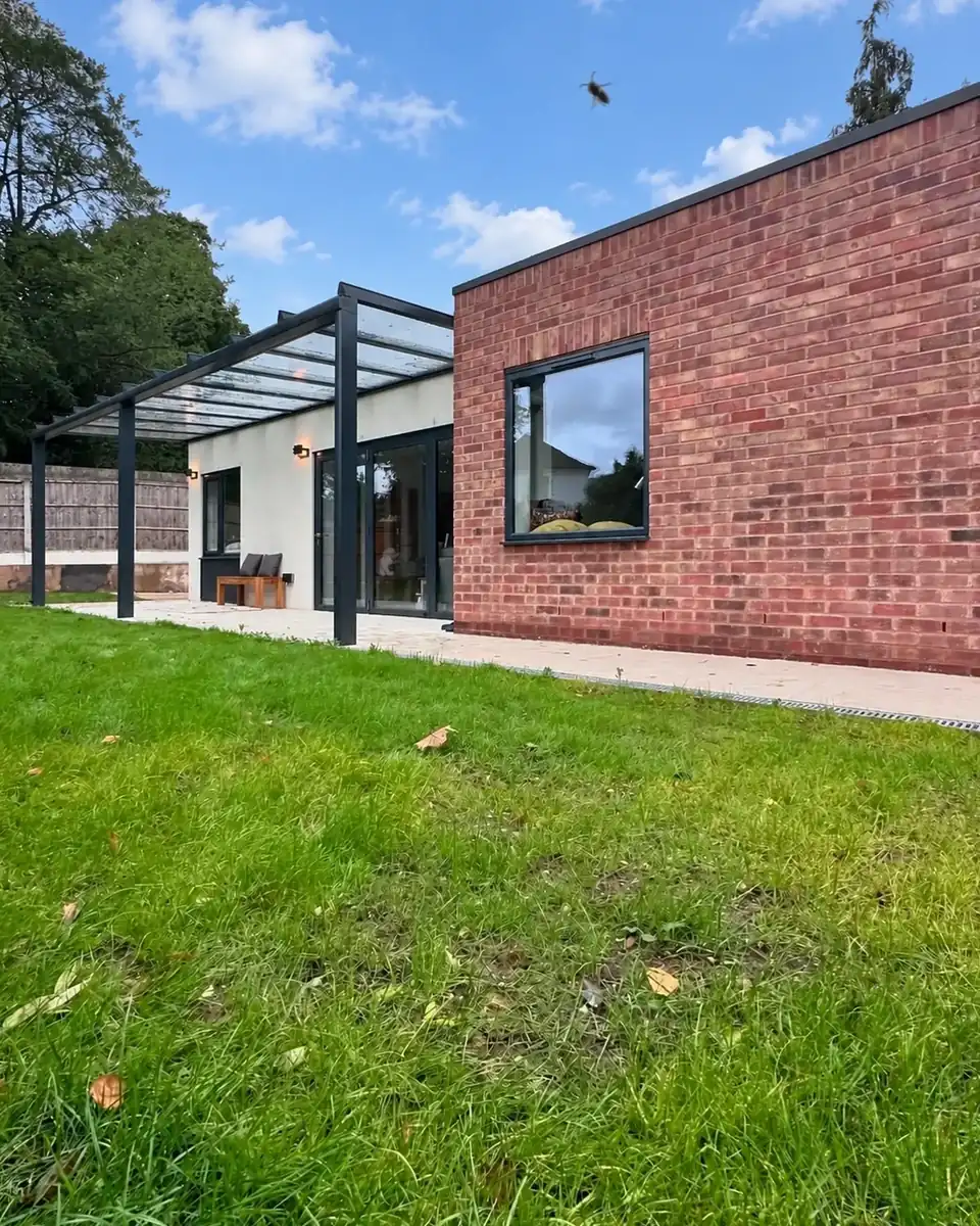 Glass veranda beside the brick wing of the lodge, seen across the lawn